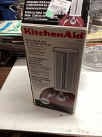Photo of the unopened KitchenAid Pasta Roller and Fettuccine Cutter Set box showing the product branding and model number.