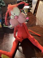 Front view of the large Bill the Cat plush toy sitting on a table, showing facial features and body markings.