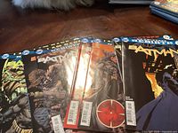 Seven Batman comics from the DC Rebirth series arranged fan-like showing front covers and barcode sections.