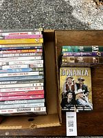 Overhead photo showing two open boxes containing DVDs with titles and series visible.