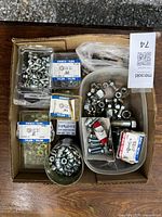 Full view of box with assorted nuts and bolts, including sealed packages and loose items in containers.