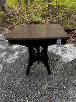 Full view of the ornate solid wood table showing rectangular top and pedestal base with detailed carved legs