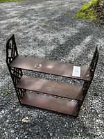 Full front view of the vintage wooden shelf showing three shelves and decorative cutout sides.