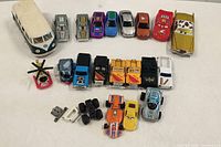 Front view of 20 assorted toy cars and vehicles laid out on a surface.