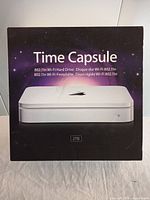 Front of box showing Apple 2TB Time Capsule with white device image and product name in multiple languages.