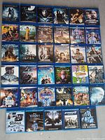 Photo showing 35 Blu-ray discs laid out, titles including Underworld series, F9, Emma, Ender's Game, Divergent, and more.
