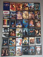 DVD collection laid out showing various superhero and sci-fi movies including Spider-Man, Avengers, Star Wars, Batman.