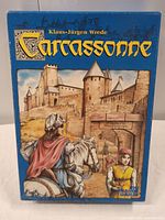 Front of Carcassonne game box with artwork of knight approaching castle and large title text