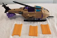 Side angle of vintage Skyhopper Transformer helicopter toy showing main rotors, cockpit, and three yellow detachable panels.