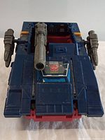 Front view of blue G1 Transformers Groundshaker featuring central gray cannon and Autobot symbol decal on hood.