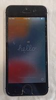 Front view of iPhone SE showing 'Hello' setup screen with scratches and wear on screen surface