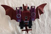 Front view of the Mindwipe figure showing the maroon and purple colors with bat wings extended, featuring Decepticon logos and robotic details.