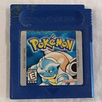 Front side of the blue Game Boy cartridge showing Pokemon Blue Version label with Blastoise character.