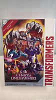 Front of the Chaos Unleashed expansion box showing artwork of multiple Transformers characters and game details.