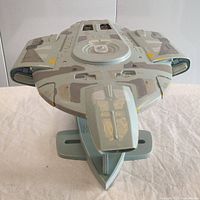 Front view of the U.S.S. Defiant scale model on display stand showing detailed painted surfaces and ship shape.