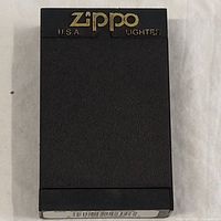 Zippo outside box showing black plastic with gold Zippo USA Lighter branding.