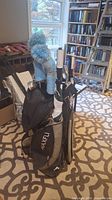 Full view of the Maxfli golf bag with clubs and two golf umbrellas attached