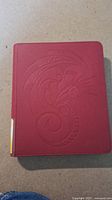 Front cover of Red Dragon Shield binder with embossed dragon design.