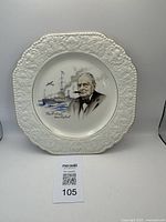 Full view of the porcelain plate showing Winston Churchill portrait with ship and plane in background along with embossed and gilded edge.