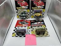 Lot of four Racing Champions NASCAR stock car die casts in original packaging arranged for identification.