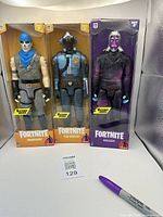 Full view of three Fortnite Victory Series action figures in original packaging showing Warpaint, The Visitor, and Galaxy characters.