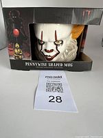 Boxed Pennywise shaped porcelain mug showing front of packaging with image of Pennywise and red balloon on left side.