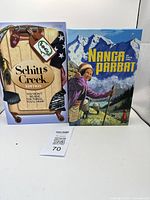Image showing the boxed Schitt's Creek Edition board game and Nanga Parbat game side by side.