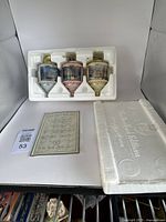 Three Thomas Kinkade porcelain Christmas ornaments set in original styrofoam packaging with certificate of authenticity and box shown