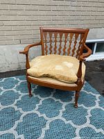 Front-left angle view of vintage Art Deco style armchair showing curved wooden arms, lattice back, and velvet cushion with visible water stains and wear.