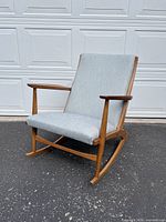 Angled front view showing slanted seat and birch frame with light blue upholstery