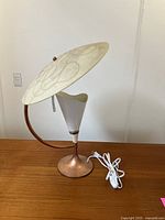 Full side view of vintage atomic-style table lamp showing large abstract patterned shade on curved metal base with electric cord.