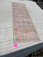 Full view of the 30x90 inch runner rug laid out on a textured grey surface showing overall condition and pattern.