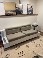 Angled front view showing gray cushions on white fiberglass base with left side magazine holder.