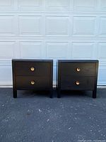 Front view of both black bedside tables side by side against garage door