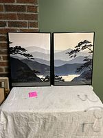 Full frontal view of the two framed Keith Mallett prints laid side by side, showing the mountain landscape designs and condition of the frames.