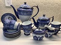 Full view of the Bombay blue and white porcelain coffee and tea set including all pieces in the set arranged together