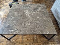 Top view showing square marble surface with natural veining and crack on one corner.