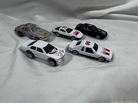 All five die-cast race cars arranged together
