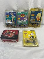 Group shot of all five items: three blister cards, collector tin, yellow blister card