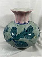 Full view of ceramic vase showing leaf motif and scalloped pink-tinted neck