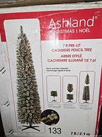 Photo of box showing Ashland brand 7 ft pre-lit Cashmere Pencil Christmas tree with assembly instructions and key features.