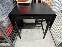 Front view of black Ingatorp desk showing single drawer and turned legs