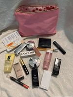 Photo shows all items laid out with clear view of pink Shiseido cosmetic bag and assorted cosmetics graded as new.