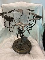 Full view of the Art Nouveau decorative metal plant stand showing its multiple leaf-shaped holders and ornate base.