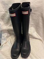 Front view of pair of black Hunter rubber boots with visible logo patch and rounded toe design.