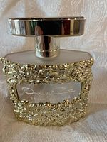 Photo of the front of the Oscar de la Renta Bella Essence perfume bottle showing gold floral embellishments and label