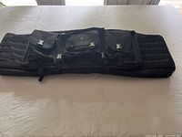 Full view of the black soft tactical double bag laid flat showing three main pouches and MOLLE webbing.