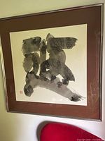 Framed square ink artwork with abstract shapes in black-grey tones with visible signature and red artist seal stamp on bottom left.