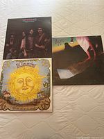 Three vinyl album covers: Eagles 'Desperado', Klaatu 'Klaatu', and Styx 'Cornerstone'.