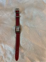 Tommy Hilfiger ladies wristwatch front view showing the rectangular face and red leather strap with white stitching.